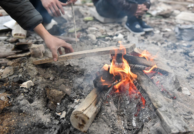 Người dân Hà Nội đốt củi sưởi ấm trên đường trong ngày mưa rét